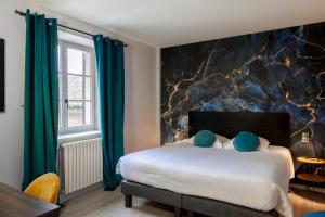 a bedroom with a large bed with green curtains at Logis Hôtel Restaurant Saint Romain in Anse