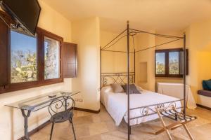 a bedroom with a canopy bed and a glass table at Villetta Il Morige in Galatone