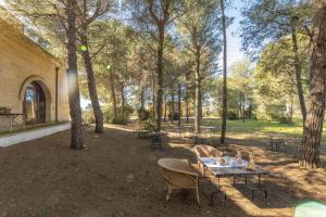 a table and chairs in a park with trees at Villetta Il Morige in Galatone