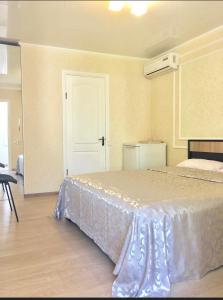 1 dormitorio con 1 cama con colcha blanca en Vilari Odessa, en Odessa