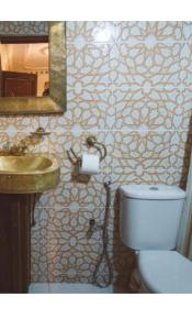 a bathroom with a toilet and a sink and a mirror at Riad lala Drissia in Fez