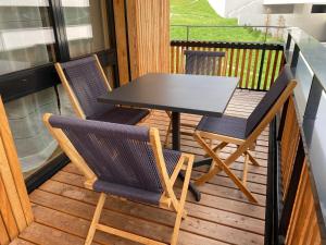 a table and two chairs on a balcony at Apartment im Stenna Vallada direkt bei den Bergbahnen in Flims
