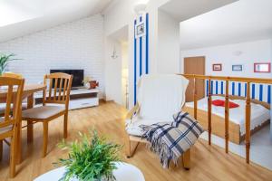 a living room with a bed and a dining table at Willa Przy Plaży in Pogorzelica