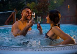 Ein Mann und eine Frau sitzen mit einem Glas Wein in einem Swimmingpool. in der Unterkunft Hotel Grand Jasná in Demänovská Dolina