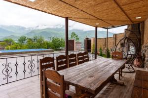 a wooden table on a balcony with a view of mountains at Avagyan's House in Ijevan