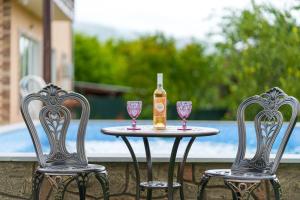 una mesa con 2 sillas, una botella y copas de vino en Avagyan's House, en Ijevan