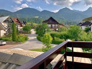 a view from the balcony of a village with mountains at Apartments Green Paradise in Bohinj