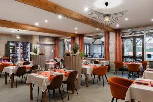 un restaurante con mesas y sillas en una habitación en Hotel-Restaurant Saint Romain Logis, en Anse