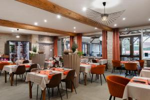 a restaurant with tables and chairs in a room at Logis Hôtel Restaurant Saint Romain in Anse