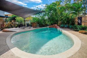 a swimming pool in a yard with an umbrella at Dunworkin Rainbow Beach in Rainbow Beach