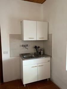 a kitchen with white cabinets and a sink at Borgo Il Monzone in Castel dʼAiano