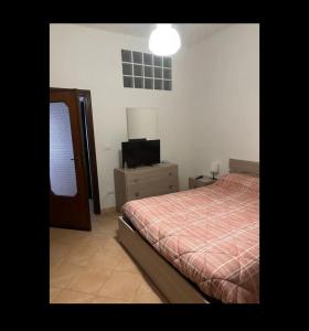 una camera da letto con un letto e una televisione di RESIDENZA LAURIOLA a Rodi Garganico