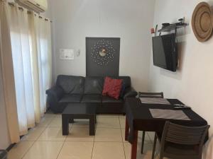 een woonkamer met een bank en een tafel bij Angelshof Self Catering Guesthouse in Windhoek