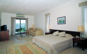 1 dormitorio con 1 cama y sala de estar en Costa 3S Beach Hotel-All Inclusive, en Bodrum City