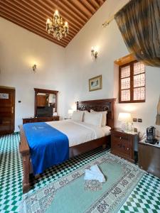 Le Riad Palais d'hotes Suites & Spa Fes في فاس: غرفة نوم بسرير كبير مع بطانية زرقاء