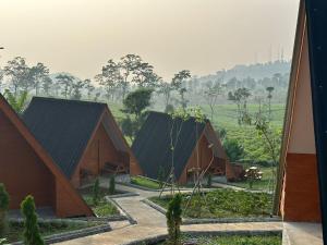a group of huts with trees in the background at Bintang Langit Lodge Ciater in Cicadas