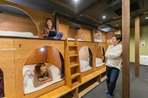 a group of people in bunk beds in a room at LAMP Iki in Iki