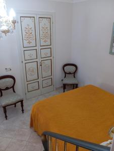 a bedroom with two chairs and a bed and a closet at La Petite Maison in Campolattaro