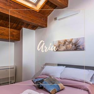 ラクイラにあるL'Aquila Home Comfortのベッドルーム1室(壁にアーニアサイン付きのベッド1台付)