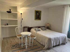 a bedroom with a bed and a table and chairs at La maison de Tina in Leugny