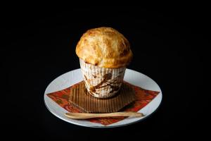 a muffin sitting on a plate on a table at Dogo Onsen Yachiyo 道後温泉八千代 in Matsuyama