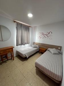 1 dormitorio con 2 camas y espejo en Apartamentos Buenavista, en Puerto Rico de Gran Canaria