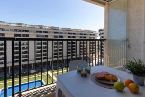瓦倫西亞的住宿－Alboraya Apartamento con vista al mar y piscina，阳台上的桌子上放着一盘水果