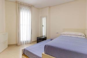1 dormitorio con 1 cama grande y edredón morado en Alboraya Apartamento con vista al mar y piscina en Valencia
