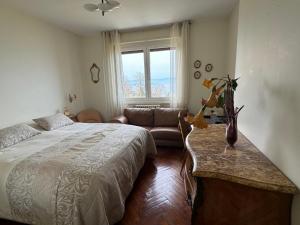 um quarto com uma cama, um sofá e uma janela em Le Bellevue em Thonon-les-Bains