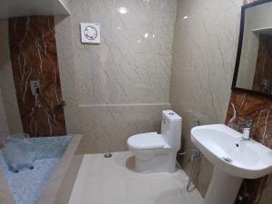 een badkamer met een wit toilet en een wastafel bij Bhumi Retreat Cottages in Shimla