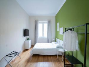 een slaapkamer met een bed en een groene muur bij La Madama Cristina in Turijn