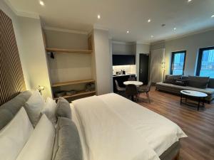 a bedroom with a large white bed and a living room at City-Studio mit Boxspring-Bett und Küche in Münster
