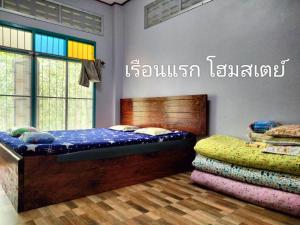 Postel nebo postele na pokoji v ubytování เรือนแรก โฮมสเตย์ Rueanraek Homestay
