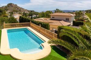 a swimming pool in front of a house at Chalet Los Olivos con piscina in Jávea