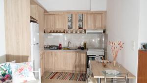 a kitchen with wooden cabinets and a table and a refrigerator at Joanna's Holiday Home in Sellía