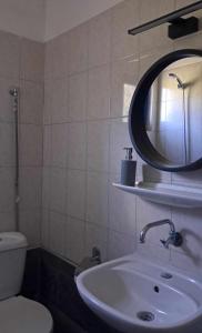 y baño con lavabo, espejo y aseo. en Meerithic ROKKA ROOMS, en Vourvourou