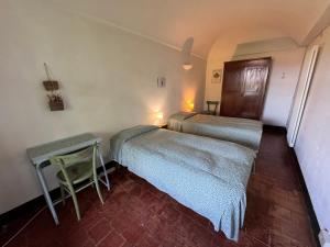 a room with two beds and a table in a room at Casa del Movimento Lento - Guesthouse in Roppolo