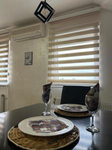 een tafel met een bord en twee glazen erop bij Apartman Gold lux in Surčin