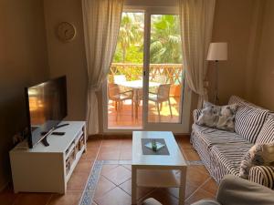 uma sala de estar com um sofá e uma mesa de centro em Apartementos Almerimar Golf em Almerimar