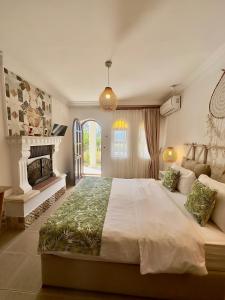 ein großes Schlafzimmer mit einem großen Bett und einem Kamin in der Unterkunft Nova Aparts in Akyaka