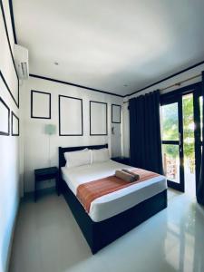 1 dormitorio con cama y ventana grande en Akalanka Homestay, en Gili Trawangan