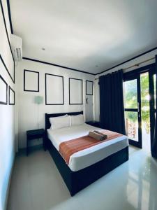 a bedroom with a bed and a large window at Akalanka Homestay in Gili Trawangan