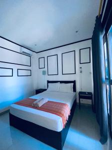 Un dormitorio con una gran cama blanca y una ventana en Akalanka Homestay, en Gili Trawangan
