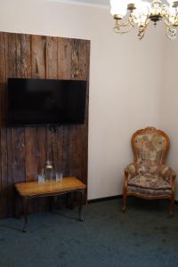 Zimmer mit einem Tisch, einem Stuhl und einem TV in der Unterkunft Tourkomplex Karpaty in Slawske