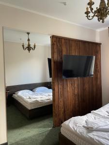 sypialnia z 2 łóżkami i telewizorem z płaskim ekranem w obiekcie Tourkomplex Karpaty w Sławsku