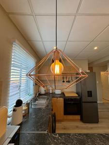 una cucina con lampadario pendente appeso a un soffitto di The Lazy Expat a Paarl