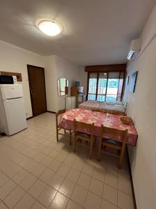 a room with a table and a kitchen with a refrigerator at RESIDENCE SOLARIUM, CORMOR 33 in Bibione