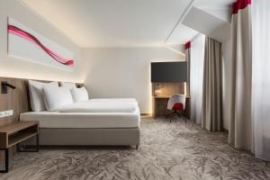 ハレにあるGood Morning+ Halle Leipzigのベッドと机があるホテルの部屋