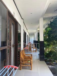 a balcony with chairs and tables on a building at Akalanka Homestay in Gili Trawangan