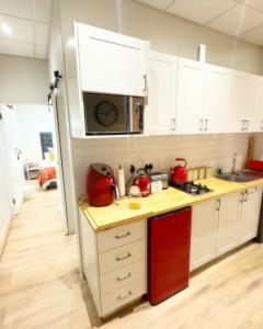 uma cozinha com armários brancos e um micro-ondas em Peper Korrel em Paarl
